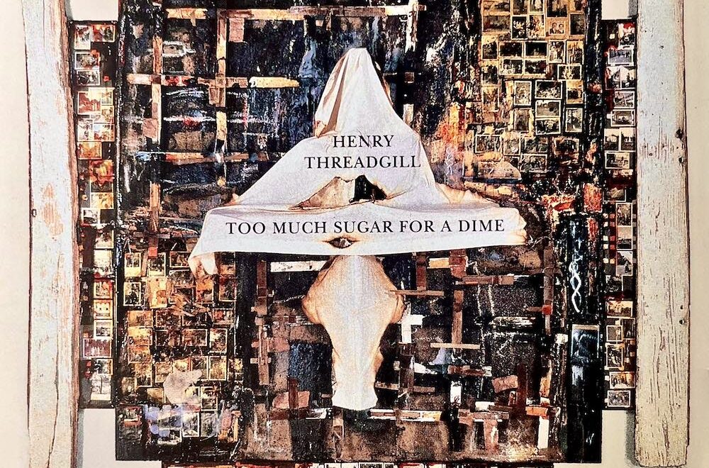 Album cover of Henry Threadgill’s Too Much Sugar for a Dime. The design features a layered collage of photographs, wooden planks, and abstract textures, with a draped white cloth at the center. Over the cloth, the artist’s name and album title appear in black text, giving the impression of a sculptural assemblage framed by rustic wood.
