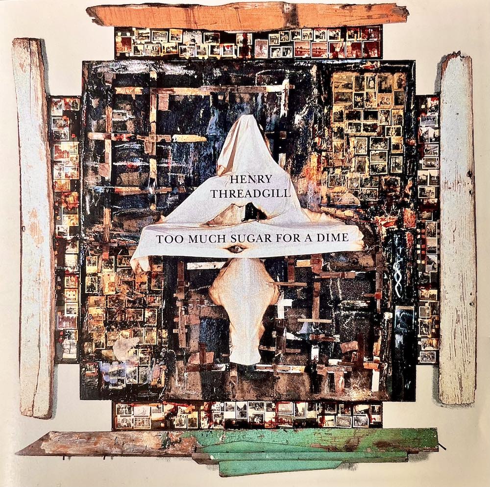 Album cover of Henry Threadgill’s Too Much Sugar for a Dime. The design features a layered collage of photographs, wooden planks, and abstract textures, with a draped white cloth at the center. Over the cloth, the artist’s name and album title appear in black text, giving the impression of a sculptural assemblage framed by rustic wood.